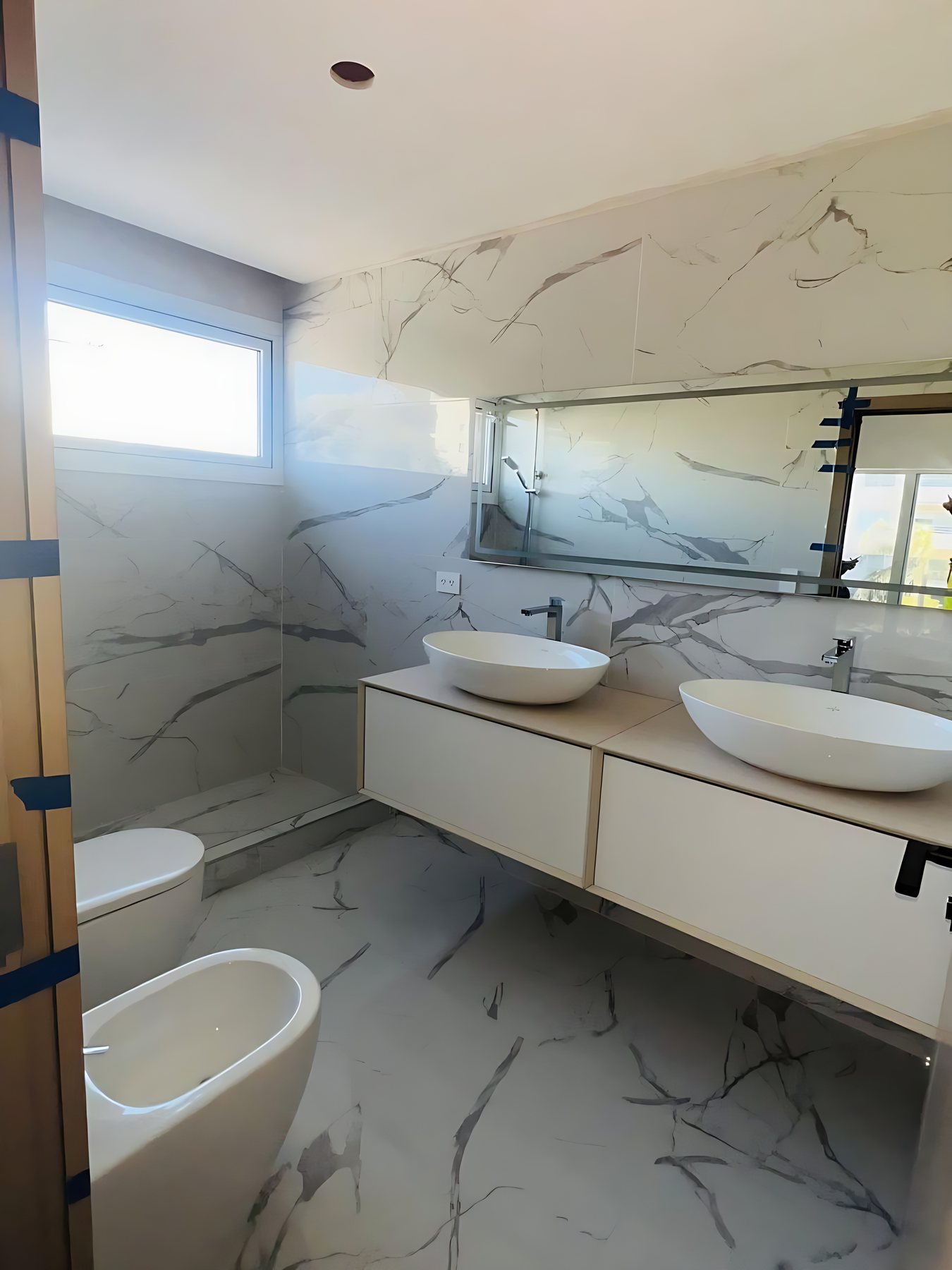 Baño con doble bacha y porcelanato símil mármol